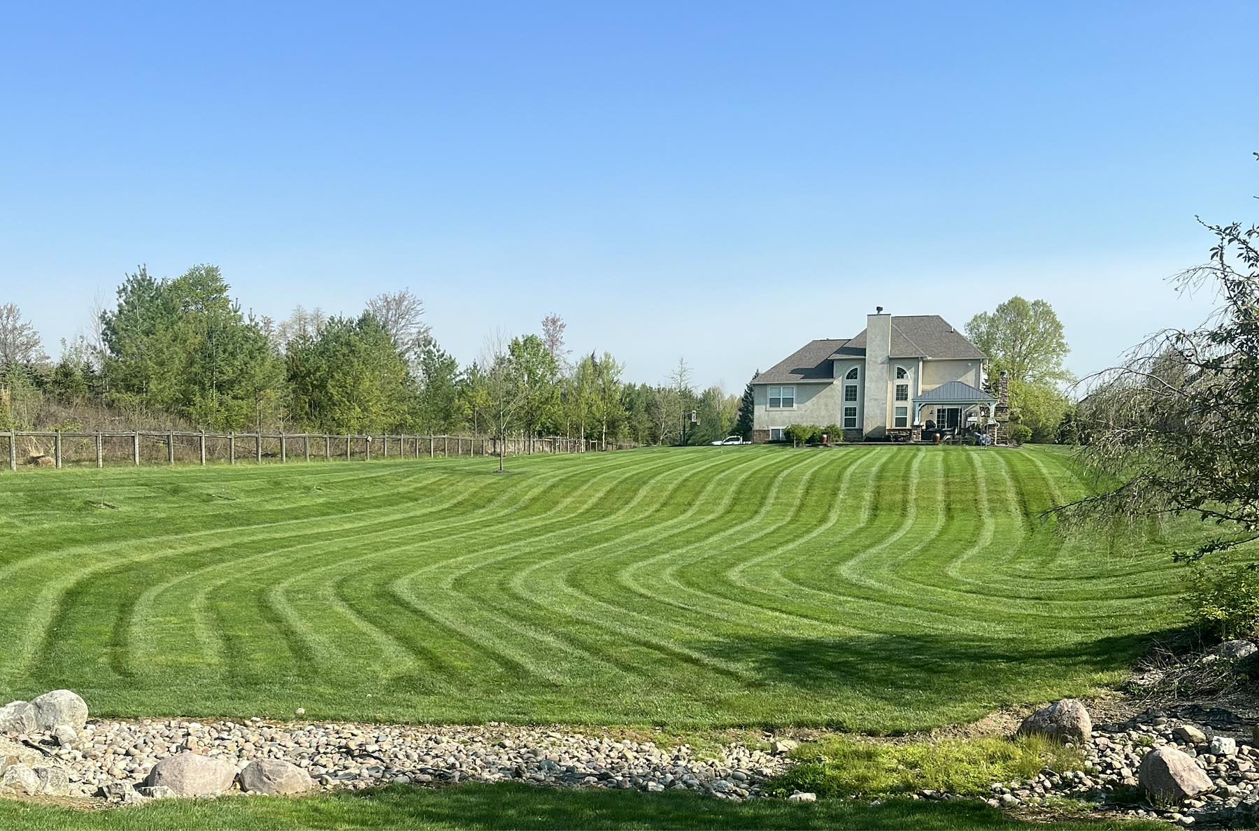 Lawn with curved mowing stripes behind a home