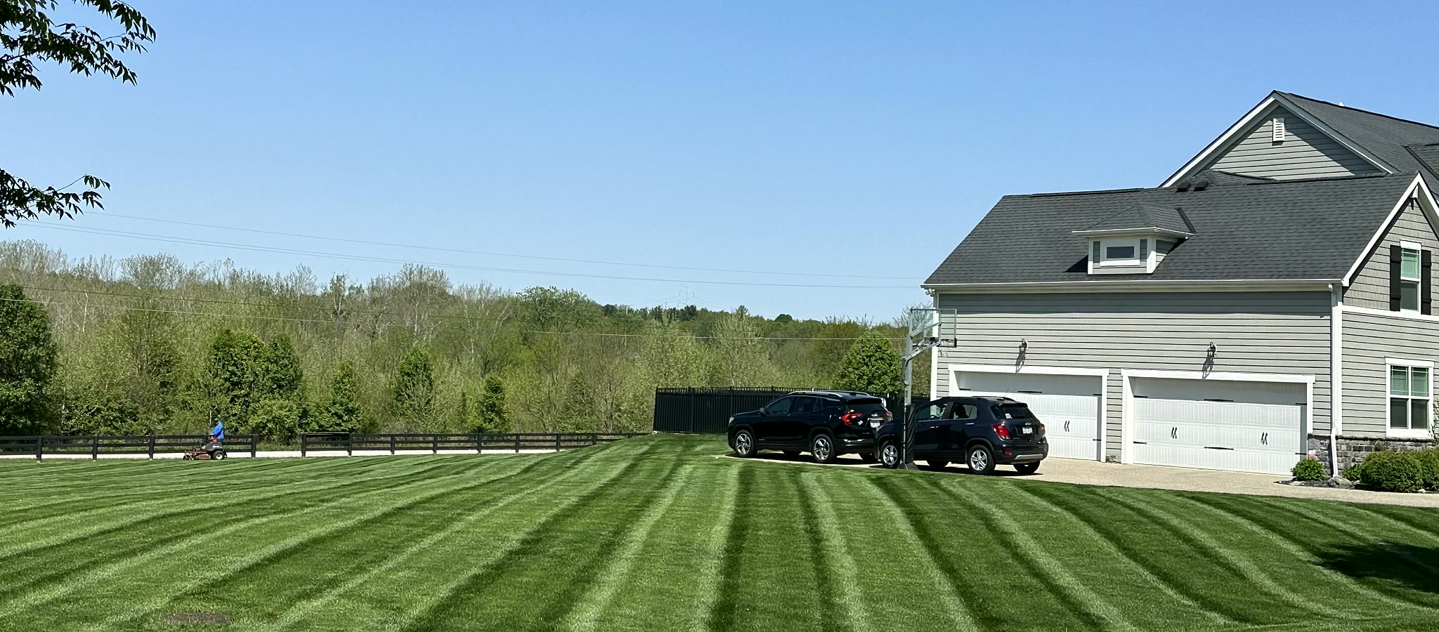 Striped lawn beside a home with a three-car garage